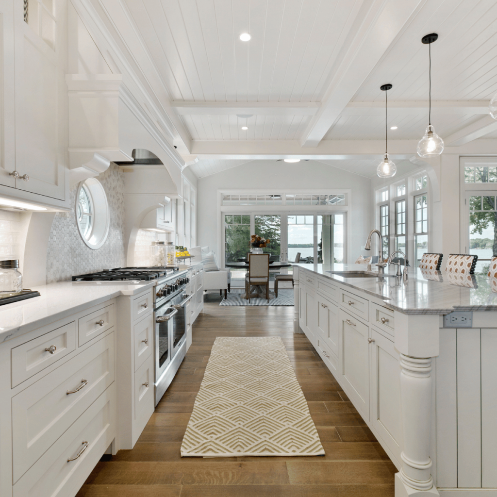 White coastal kitchen with long island and wood floors.